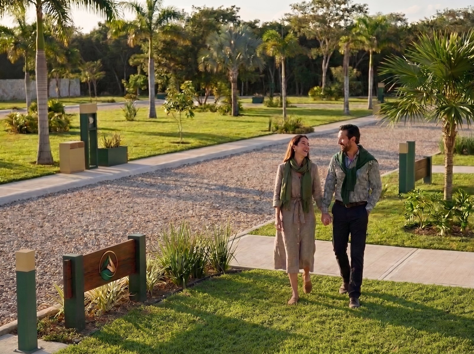 Pareja caminando hacia el acceso de VERALTA Villas Tlacotengo, junto al letrero de entrada